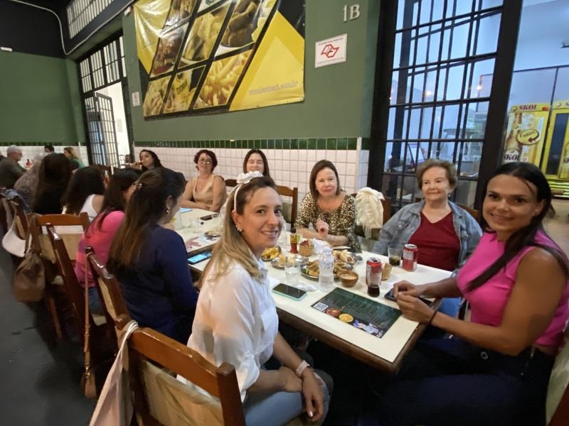 Clientes conversando em volta de uma mesa no Bar do Ari