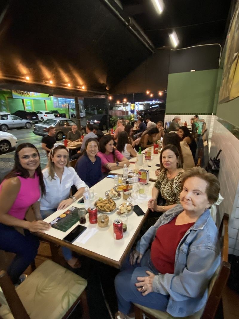 Grupo de amigas em uma mesa comprida no Bar do Ari